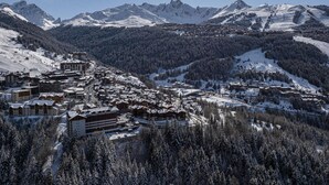 A snow-covered mountain town with buildings and a ski resort.