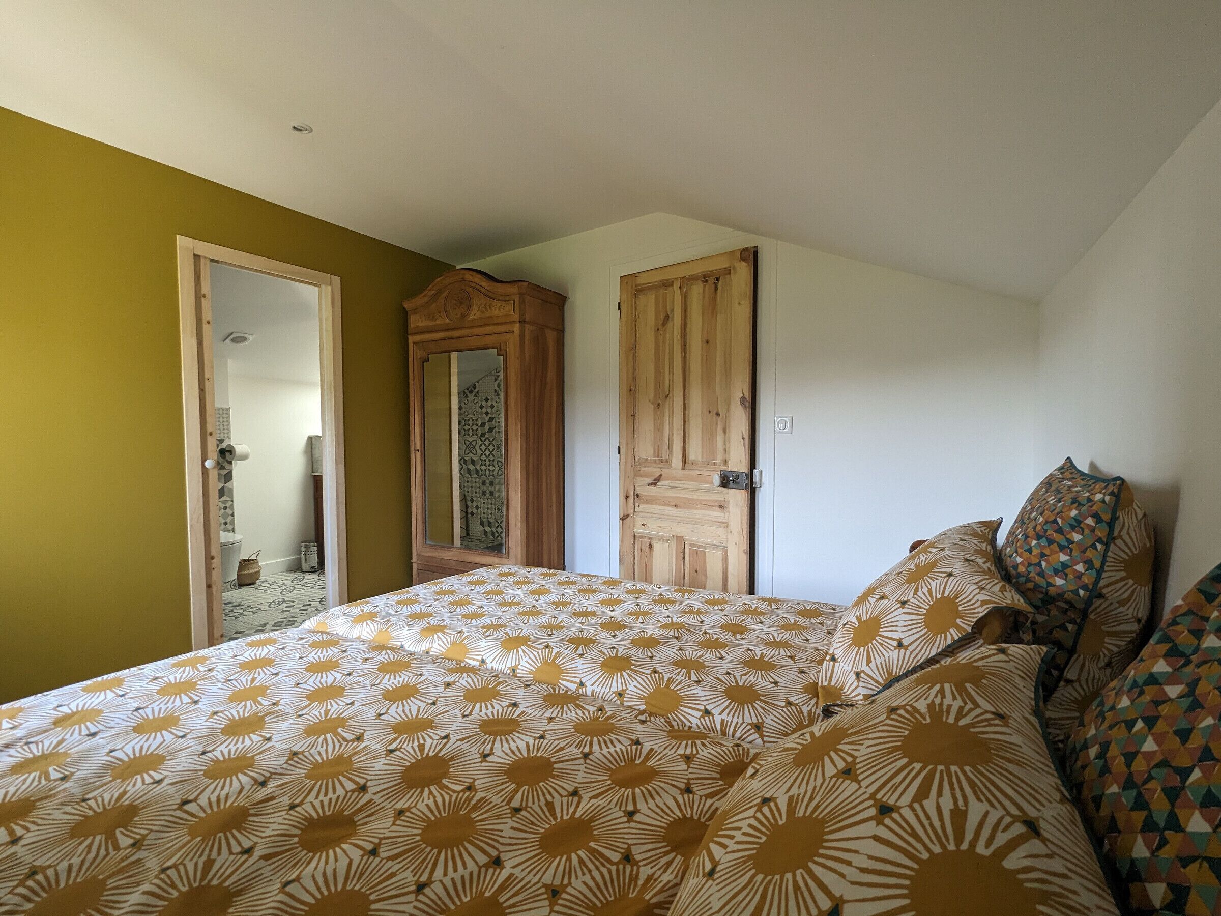 A bedroom with a bed, a wardrobe, and a door.