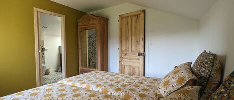 A bedroom with a bed, a wardrobe, and a door.