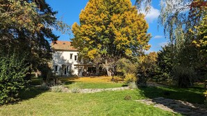 Una casa con jardín, césped y un camino de piedra.