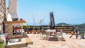 A patio with a stone sink, outdoor seating, a grill, and potted plants. - Apartment 'Ventus Pandora' with Sea View, Wi-Fi and Air Conditioning (Lefkada)