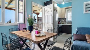 A dining area with a wooden table, metal chairs, and a view of the kitchen. - Apartment 'Ventus Kalipso' with Sea View, Wi-Fi and Air Conditioning (Lefkada)