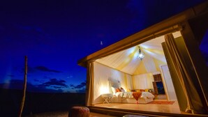 Un dormitorio acogedor y bien iluminado con cama, mesita de noche y una lámpara colgante.