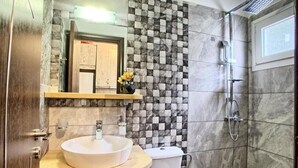 A bathroom with a round sink, a toilet, a shower, and a tiled wall. - Apartment 'Ventus Artemis' with Sea View, Wi-Fi and Air Conditioning (Lefkada)