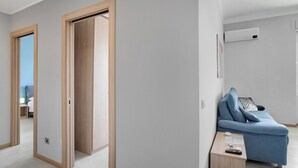 Una stanza moderna con una porta in legno, un divano blu e un tavolino con un telecomando.