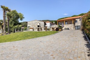 A stone building with a tiled roof, a paved pathway, and a grassy area. - Holiday Home 'Da Lage' with Sea View, Wi-Fi and Air Conditioning (Castelo do Neiva)