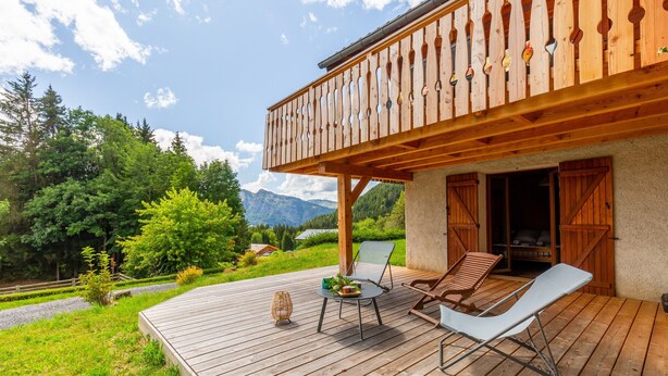 A wooden deck with outdoor furniture, a balcony with wooden railings, and a mountainous backdrop. - Chalet "L'Oréade" with Mountain Views, Private Terrace and Wi-Fi (Manigod)