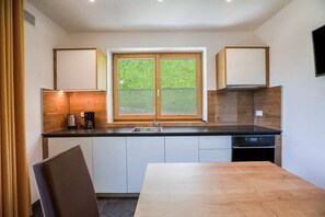 Une cuisine moderne dotée d’une grande fenêtre, de meubles en bois et d’une table à manger.