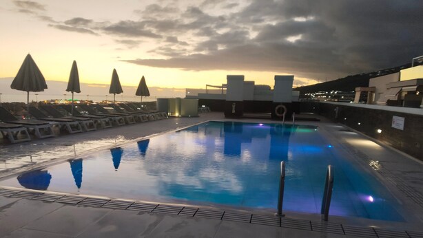 A rooftop pool with lounge chairs and umbrellas, surrounded by buildings. - Vacation Home 'Suite Mirador Del Galeón' with Sea View, Wi-Fi and Air Conditioning (Adeje)