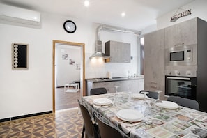 Una cocina moderna con microondas, horno y comedor dispuesto con platos y vasos.