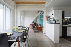 A modern kitchen with a dining area, a staircase, and a view of the living room. - Tourellic duplex *** vue mer, 2 chambres, 5 pers. (Binic-Étables-sur-Mer)