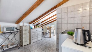 A kitchen with a wooden ceiling, a white countertop, a kettle, and a small plant. - Apartment 'Isola Di Giava Holiday' with Private Terrace, Wi-Fi & Air Conditioning (Sorso)