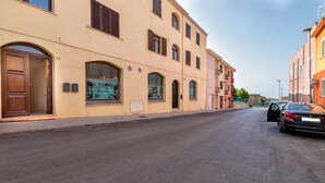 A street with buildings, a car, and a door. - Apartment 'Isola Di Giava Holiday' with Private Terrace, Wi-Fi & Air Conditioning (Sorso)