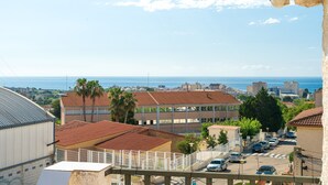 Un paisaje urbano costero con edificios, cielo despejado y vista al mar.