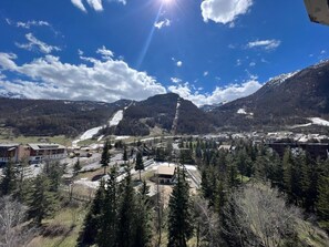 Eine gebirgige Landschaft mit einer Stadt im Tal, mit Gebäuden mit flachen Dächern und einer Mischung aus moderner und traditioneller Architektur.