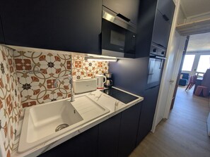 A modern kitchen with a built-in microwave, a coffee maker, and a toaster.