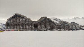 Un hôtel à plusieurs étages doté d’une architecture moderne, avec des balcons et un toit plat.