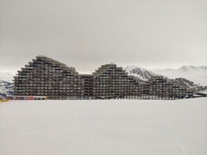 A multi-story hotel with a modern architectural design, featuring balconies and a flat roof.