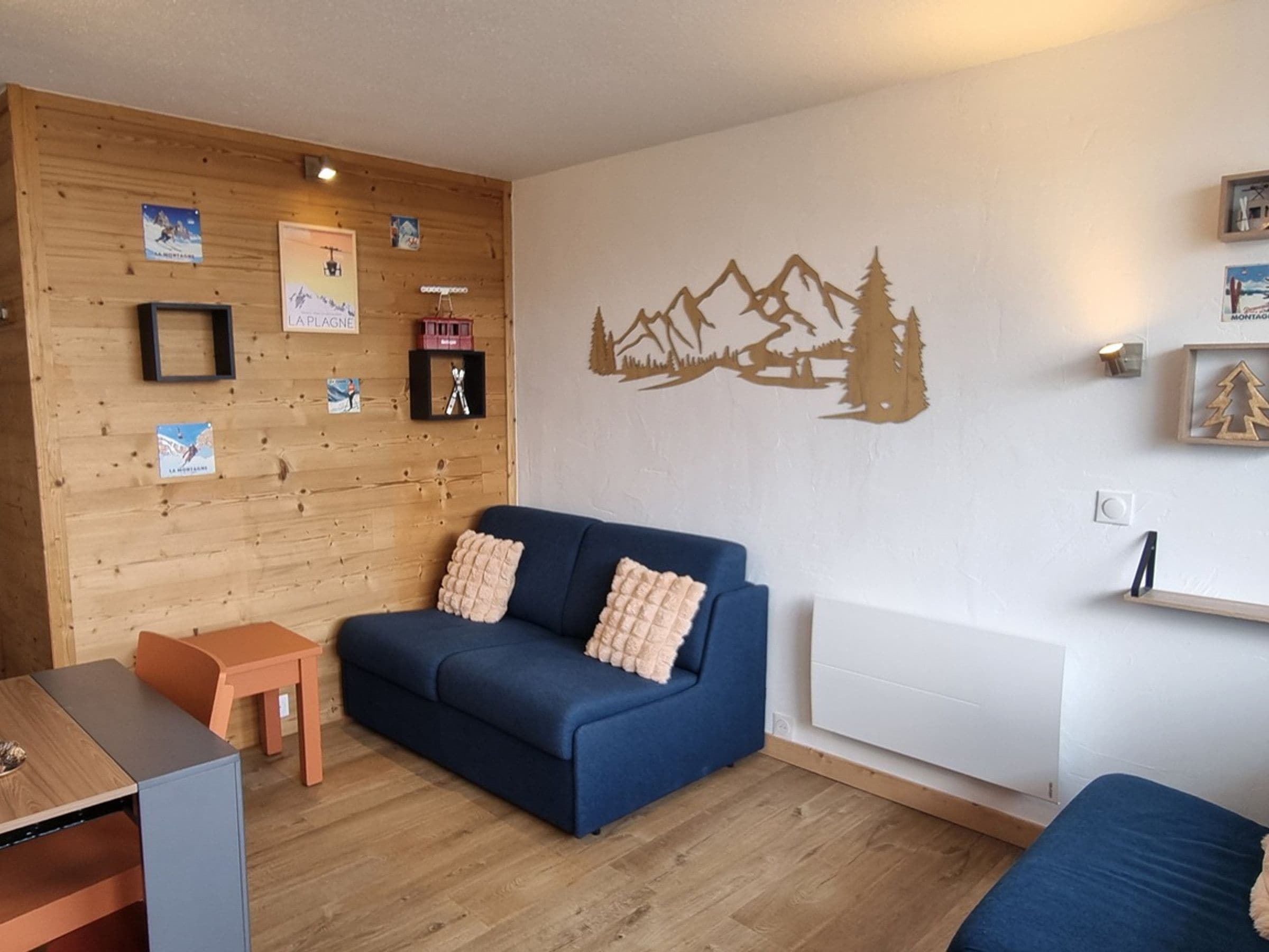 A cozy room with a blue sofa, a small wooden table, and a radiator.
