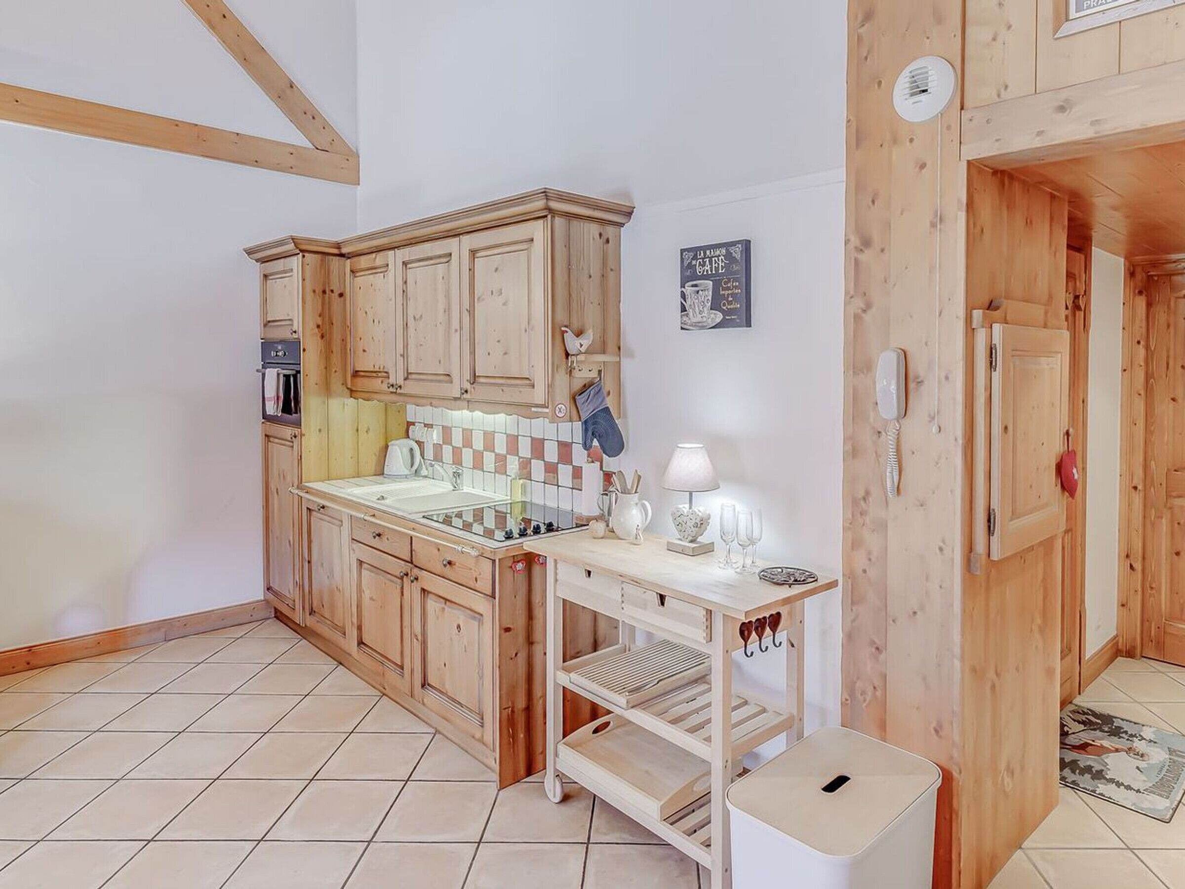 A compact kitchen with wooden cabinets, a tiled backsplash, and a small countertop.