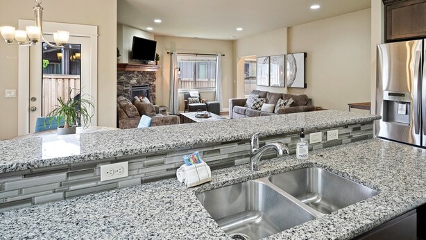 A modern kitchen with granite countertops, stainless steel appliances, and a built-in sink.