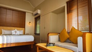 A hotel room with a bed, a sofa, a small table, and a wardrobe. - Sea Escape Koh Chang (Ko Chang)