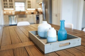 A wooden table with a tray holding three vases.