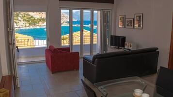 Relax in a spacious living area with a sofa and couch, overlooking a scenic coastal view.
