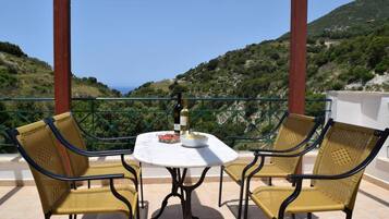 Una terraza con mesa y sillas, con vistas a un paisaje montañoso.