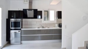 A modern kitchen with stainless steel appliances, a built-in oven, and a dishwasher.