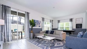 Ein modernes Wohnzimmer mit einer Couch, einem Couchtisch und einem großen Fenster.