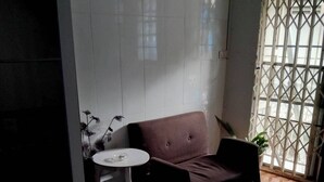 A room with a brown sofa, a small round table, and a potted plant.