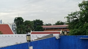 A rooftop terrace with white plastic chairs and a blue wall.