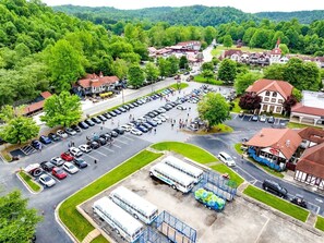 An aerial view of a parking lot with buses, a bus depot, and surrounding buildings.