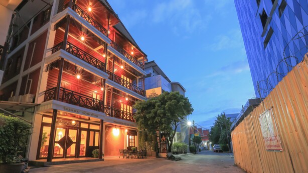 Un hotel con numerosi balconi, un ristorante e vista sulla strada.