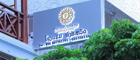 A sign for Phong Savath Boutique Hotel with contact information.