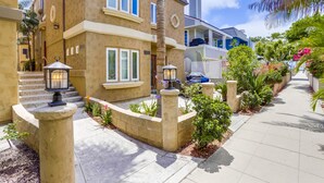 A residential building with a two-story structure, a front entrance with steps, and a landscaped garden area. - Dover Vistas - Ocean View w/ Rooftop Terrace, Firepit, Fast WiFi, AC & Parking! (San Diego)