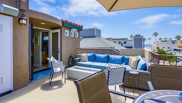 A rooftop terrace with a sofa set, chairs, and a dining table. - Dover Vistas - Ocean View w/ Rooftop Terrace, Firepit, Fast WiFi, AC & Parking! (San Diego)
