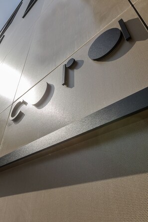 A metallic wall with a textured surface and a circular emblem.