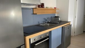 Una cocina compacta equipada con horno, fregadero y lavavajillas.