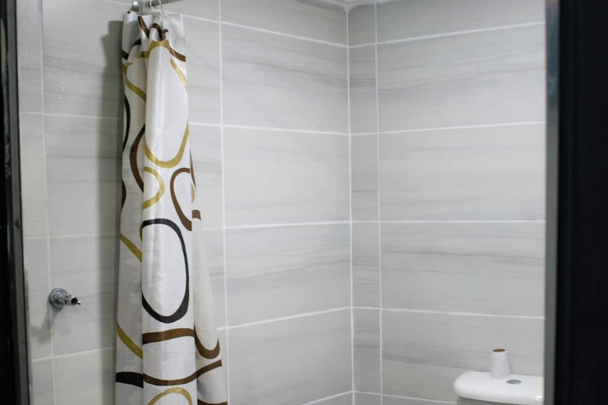 A small bathroom with a shower curtain, a toilet, and a sink.