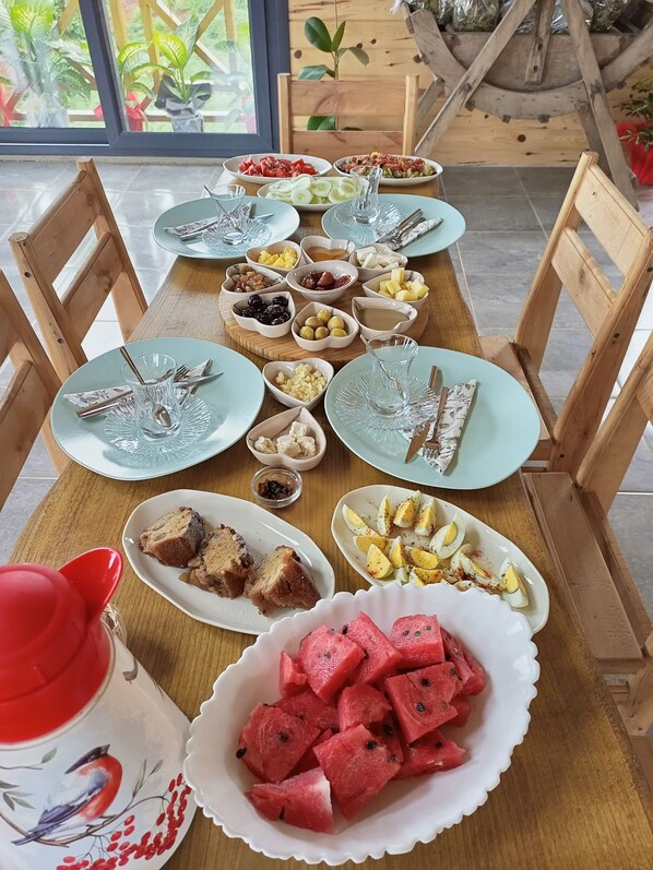 A dining table set with various dishes and a red cup. - Pamira Bungalow (Surmene)