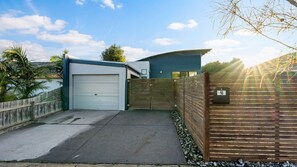 Stylish home with a garage, mailbox, and garden surrounded by a fence.