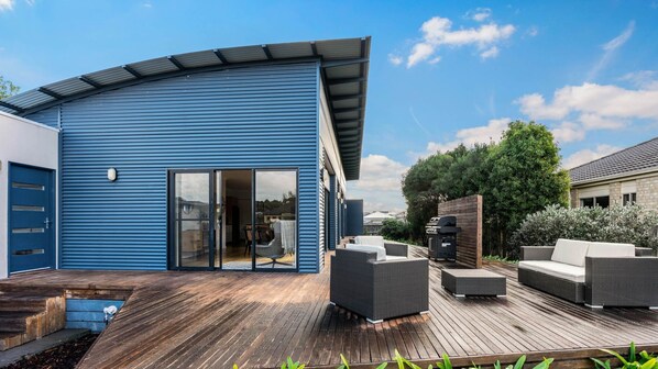 Enjoy an outdoor living space with a deck, barbecue grill, and wicker furniture.