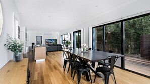 Enjoy meals at the large dining table surrounded by comfortable seating.