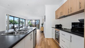 Enjoy cooking in this well-lit kitchen with an oven, stainless steel sink, and ample cabinetry.