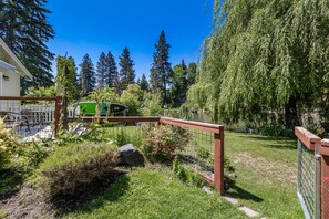 outdoor space with a fenced area, trees, and a dock for a boat.
