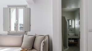 Une chambre moderne avec un canapé, un chapeau et un livre ouvert.
