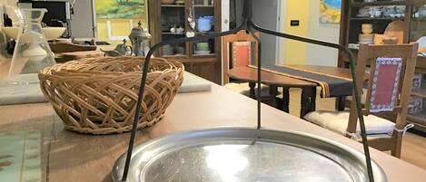 Una cocina con una bandeja metálica redonda, una cesta de mimbre y un armario con puertas de vidrio.