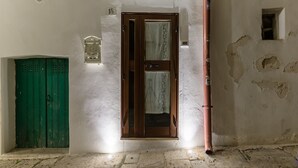 Ein Flur mit einer grünen Tür, einer Holztür mit Vorhang und einer Wand mit einer Nummer.'